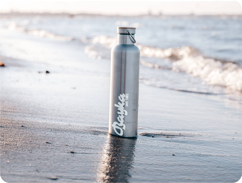 Stainless steel water bottle with the Bayka logo at a water dispenser